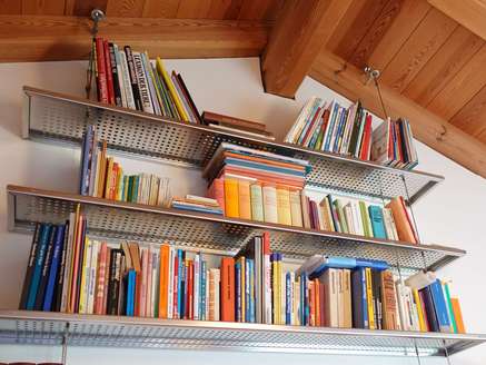 Bücherregal aus Edelstahlfachböden und Stahlseilen 